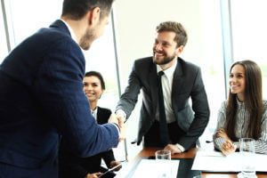 Small business banking technology - men shaking hands in meeting